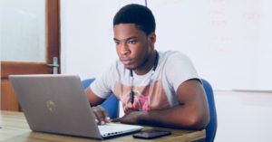 Coder sitting at a computer creating course content.