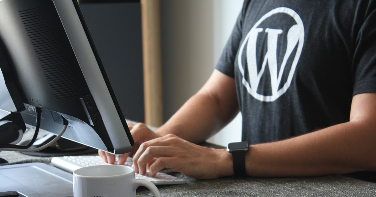 Developer at a computer wearing a WordPress t-shirt