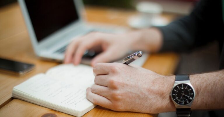 person taking notes at a computer for online training