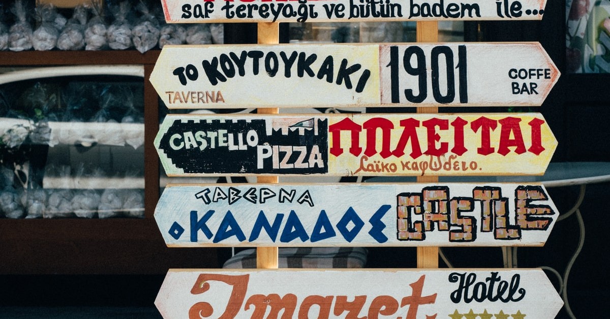 A sign with many languages pointing in different directions