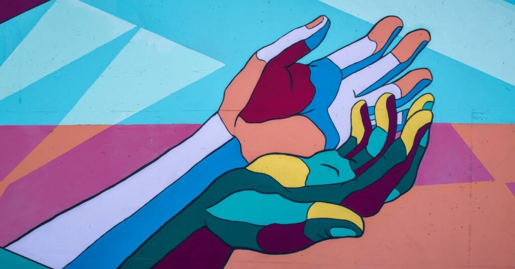 multi colored hands reaching up