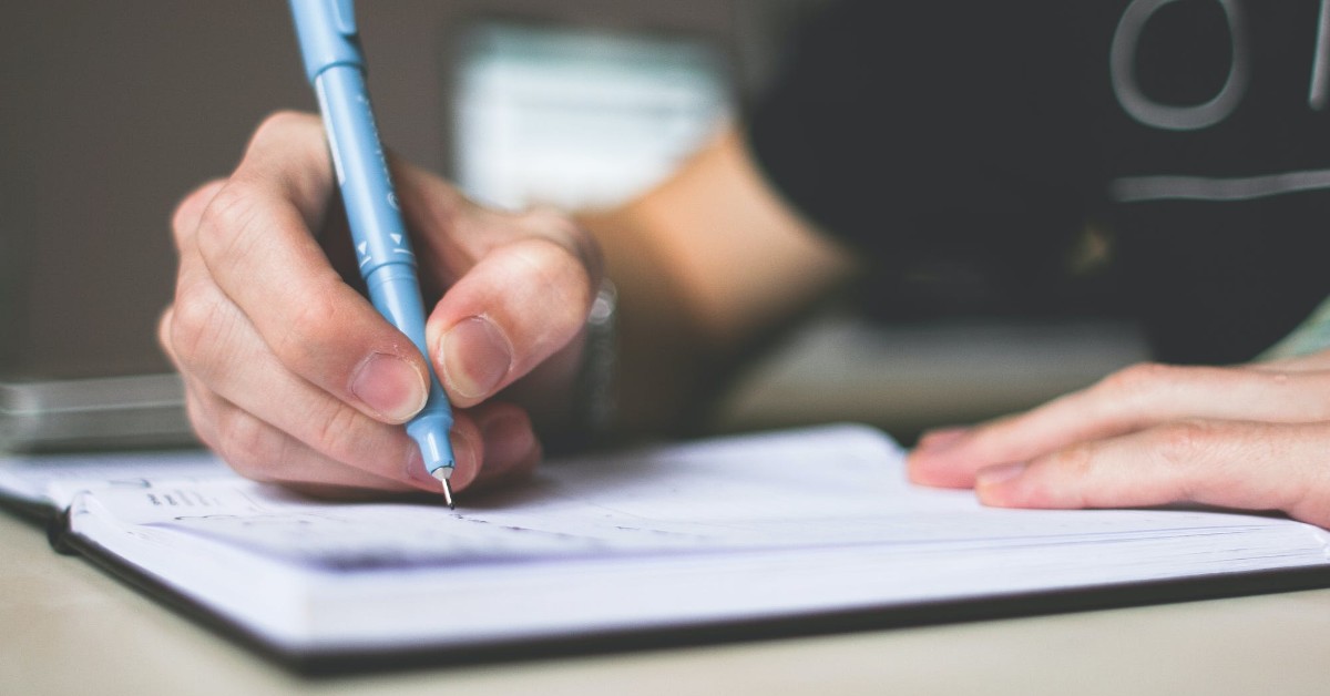 learner writing an essay in a notebook