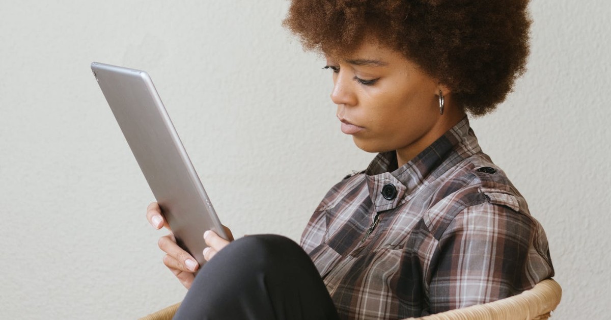 black woman reviewing a tablet while she conducts remote training