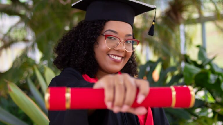 A woman holding out a diploma upon graduation.