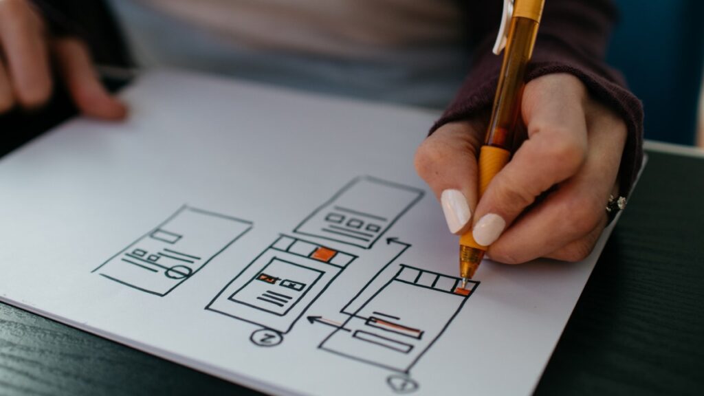 A person with paper draws out a graph of user experience.