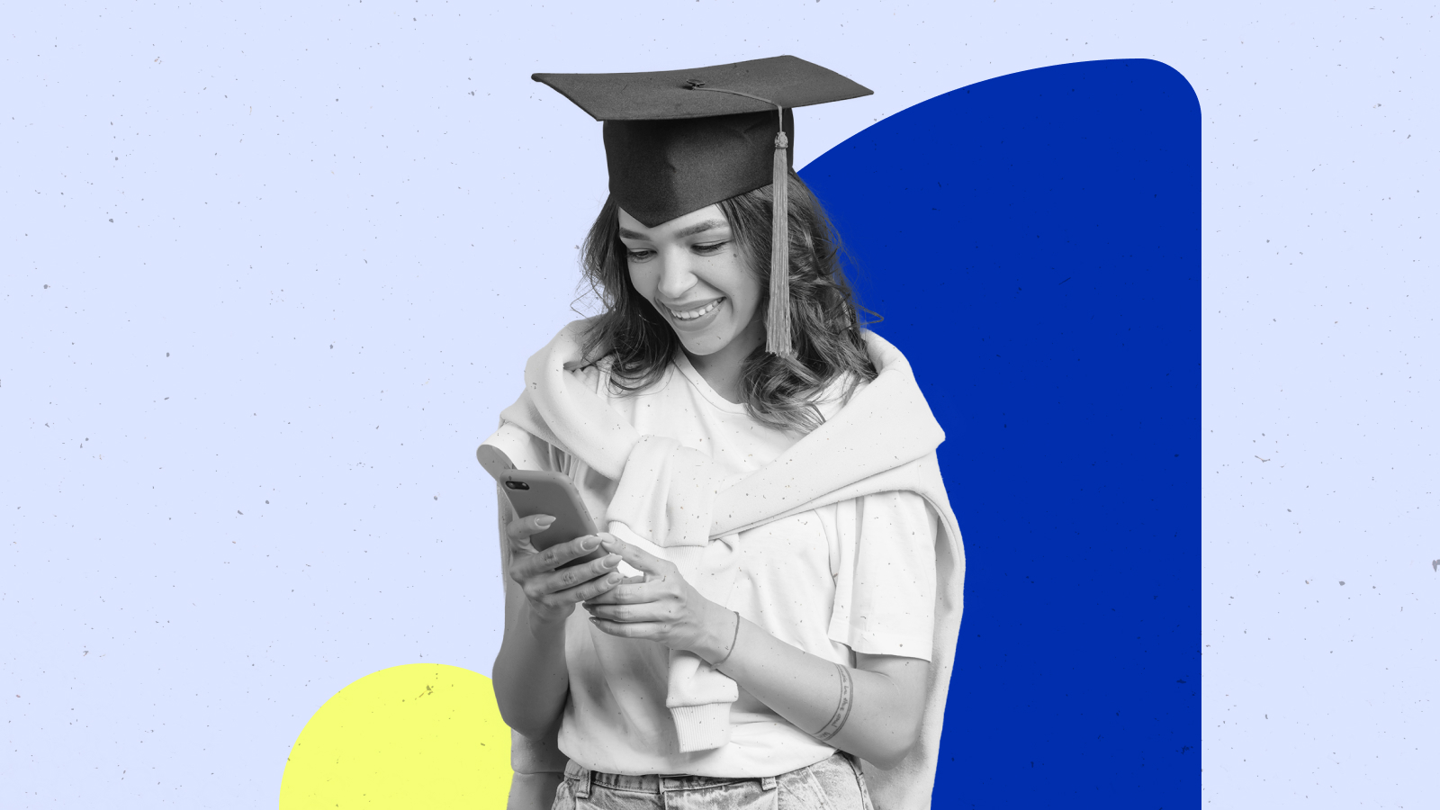 a woman in a graduation gown looking down at her mobile device