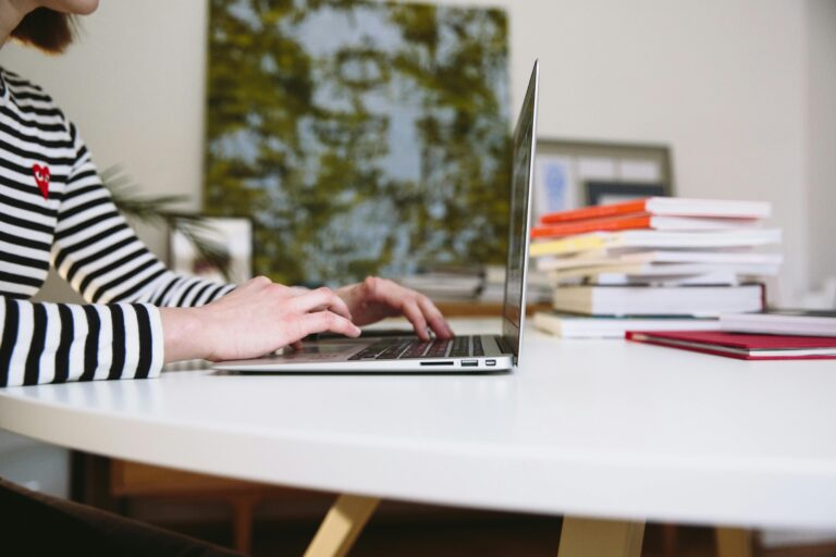 Person typing on laptop on a desk.