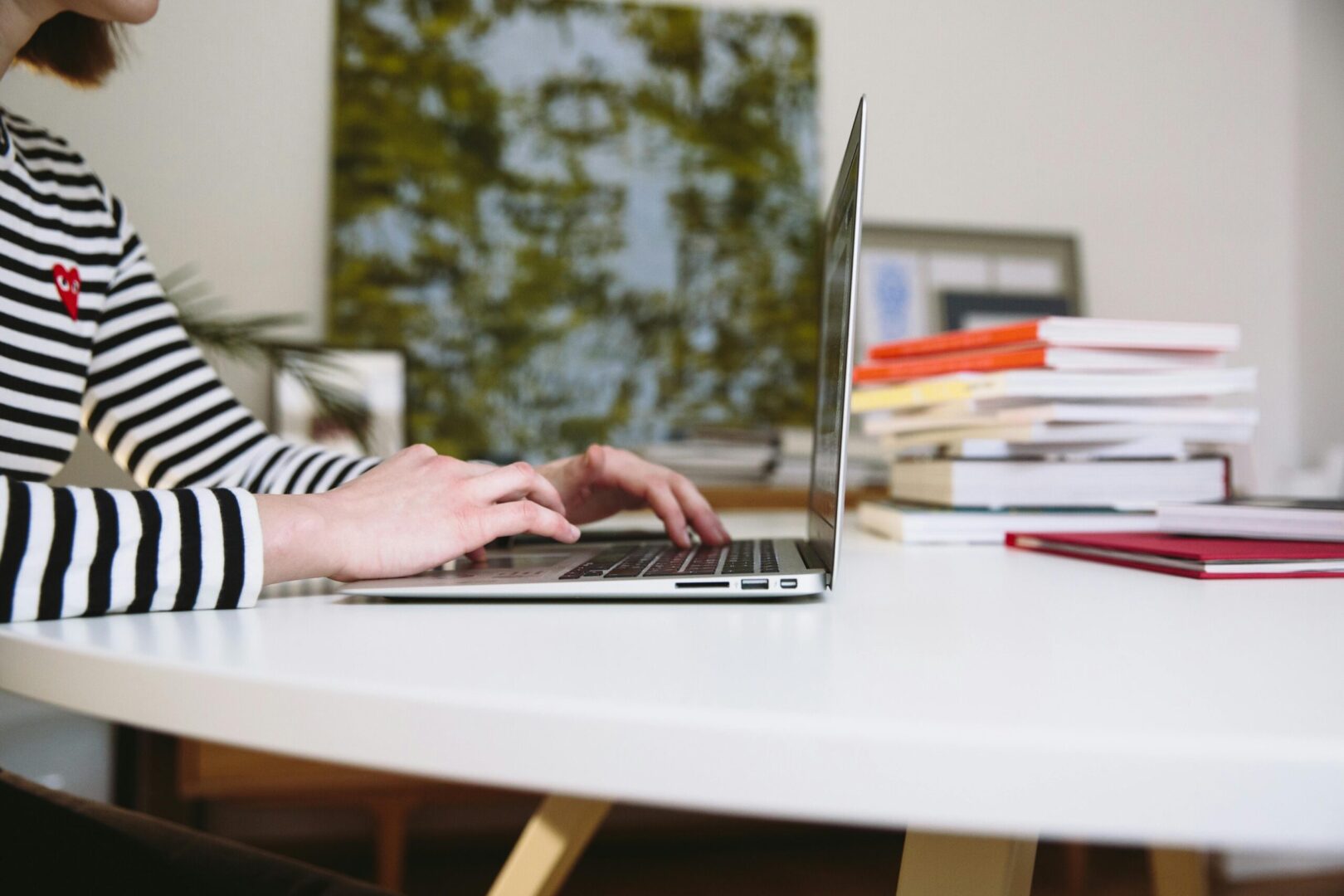 Person typing on laptop on a desk.