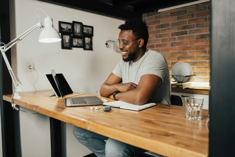 Man working at a table with a laptop in his home