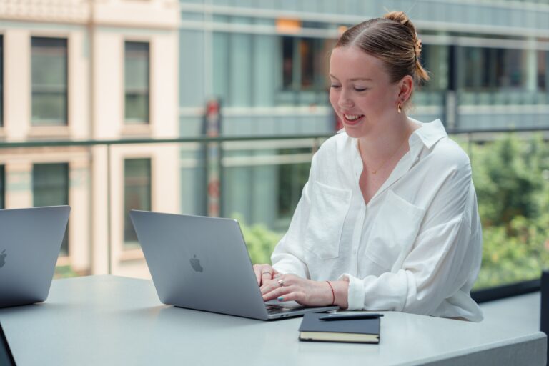 person using laptop on outside table