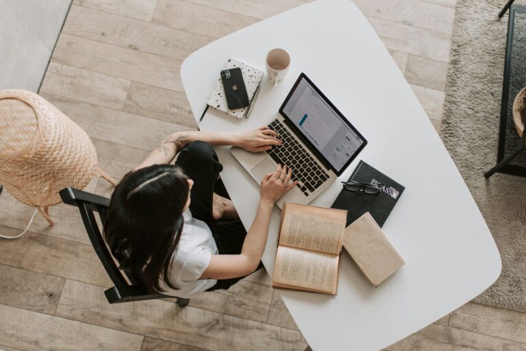 Person working on laptop on a desk.
