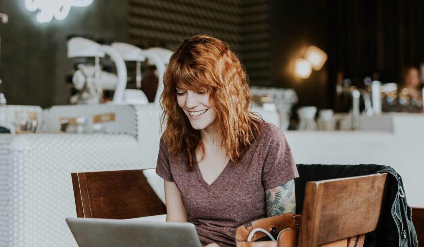 smiling person using laptop